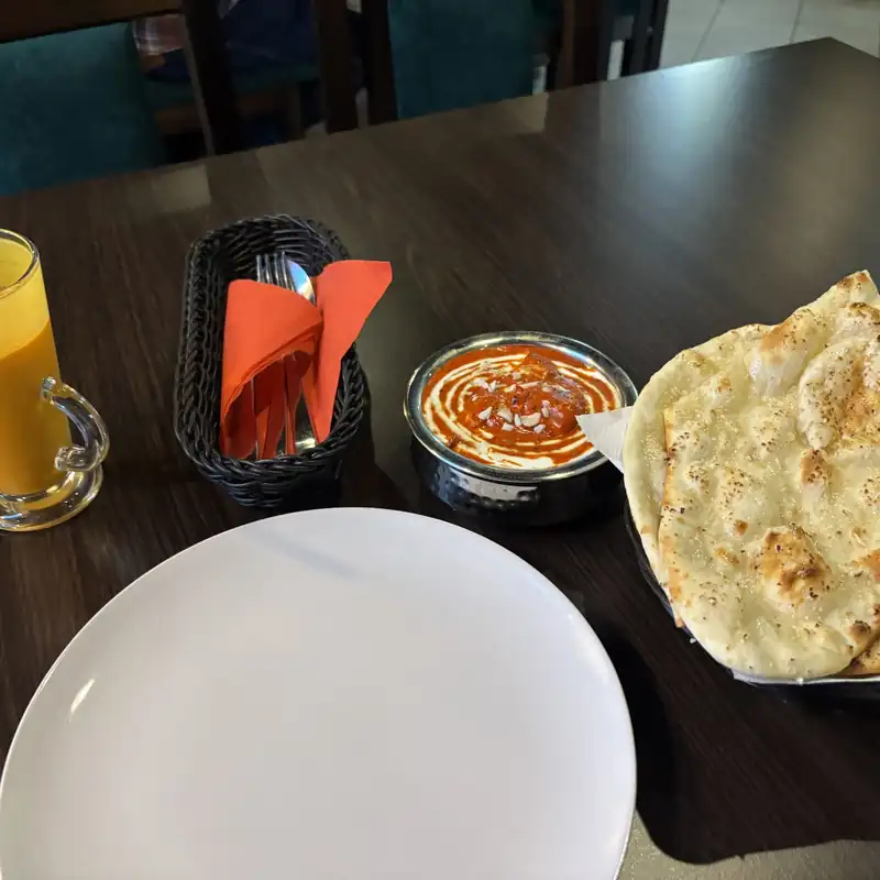 Mango lassi, naan i curry w miedzianej miseczce